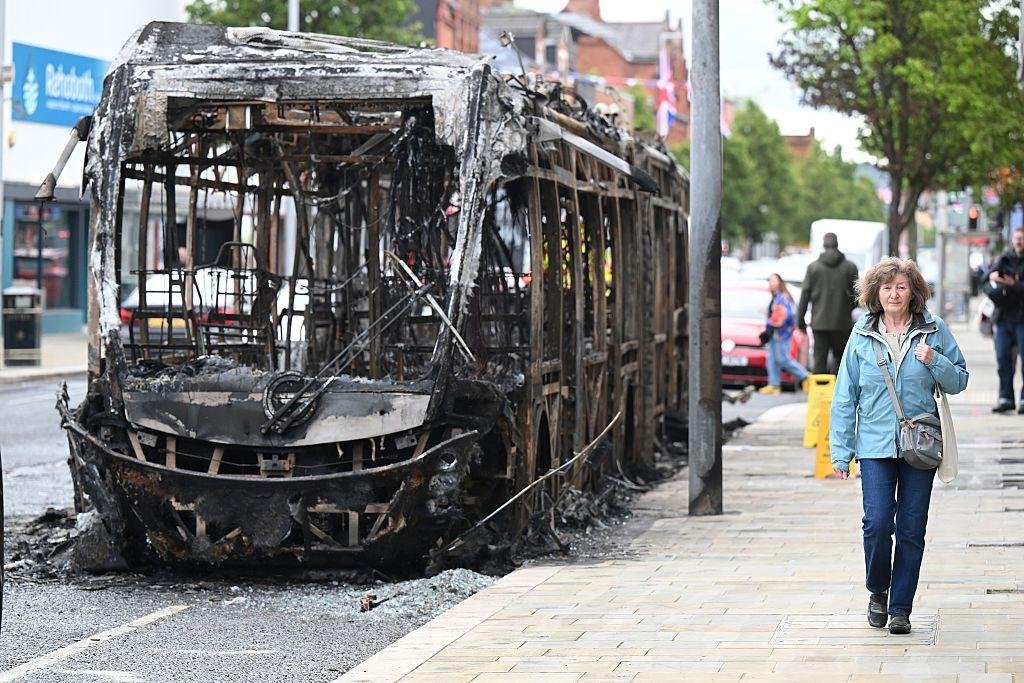 حافلة محترقة على طريق نيوتاوناردز، مع بدء أعمال التنظيف عقب ليلة من أعمال الشغب المناهضة للمهاجرين في بلفاست، أيرلندا الشمالية، في 10 يونيو/حزيران 2026.